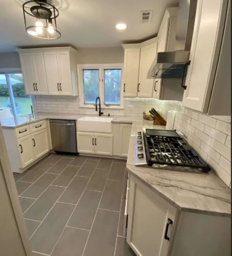 Modern kitchen renovation with white shaker cabinets, farmhouse sink, stainless steel appliances, and subway tile backsplash PA