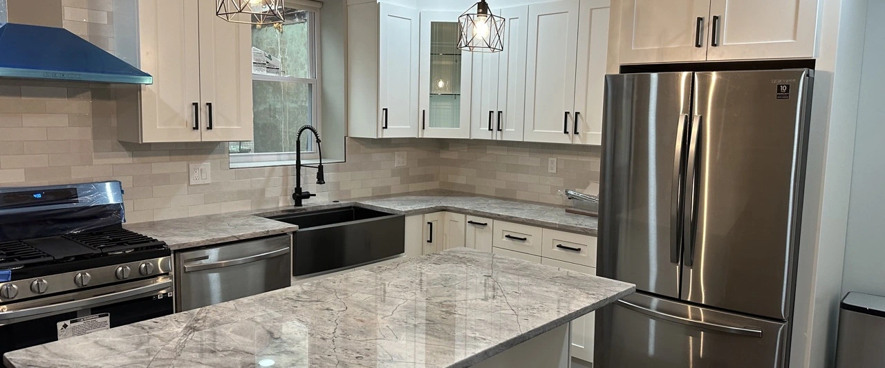 White shaker kitchen cabinets with a marble-look quartz counter