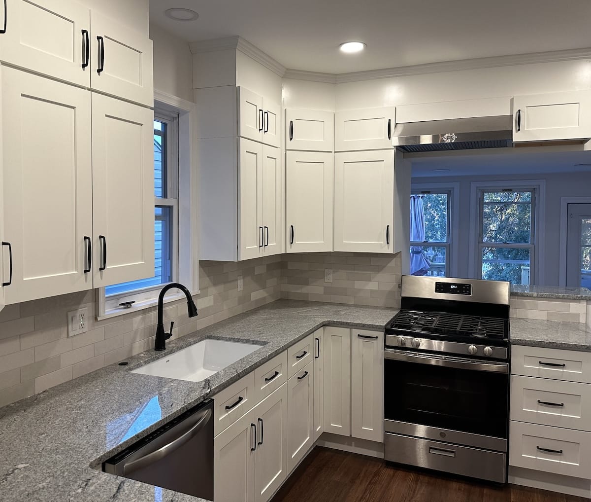 White kitchen with shaker cabinets, a farmhouse sink, and a gas range