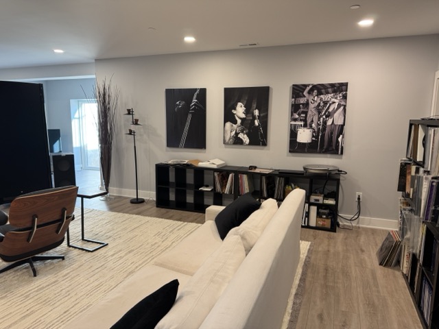 Finished basement living room with light wood-look flooring