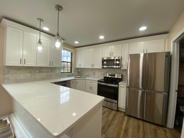 White kitchen remodel with an island and gray subway tile