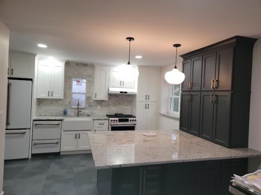 White kitchen remodel with an island and gray subway tile