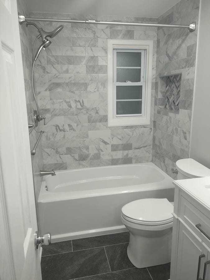Teal tiled walk-in shower beside a dark vanity
