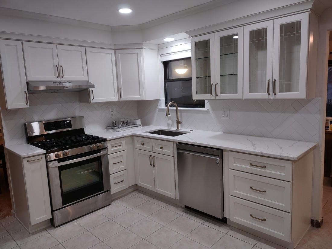 White kitchen remodel with an island and gray subway tile