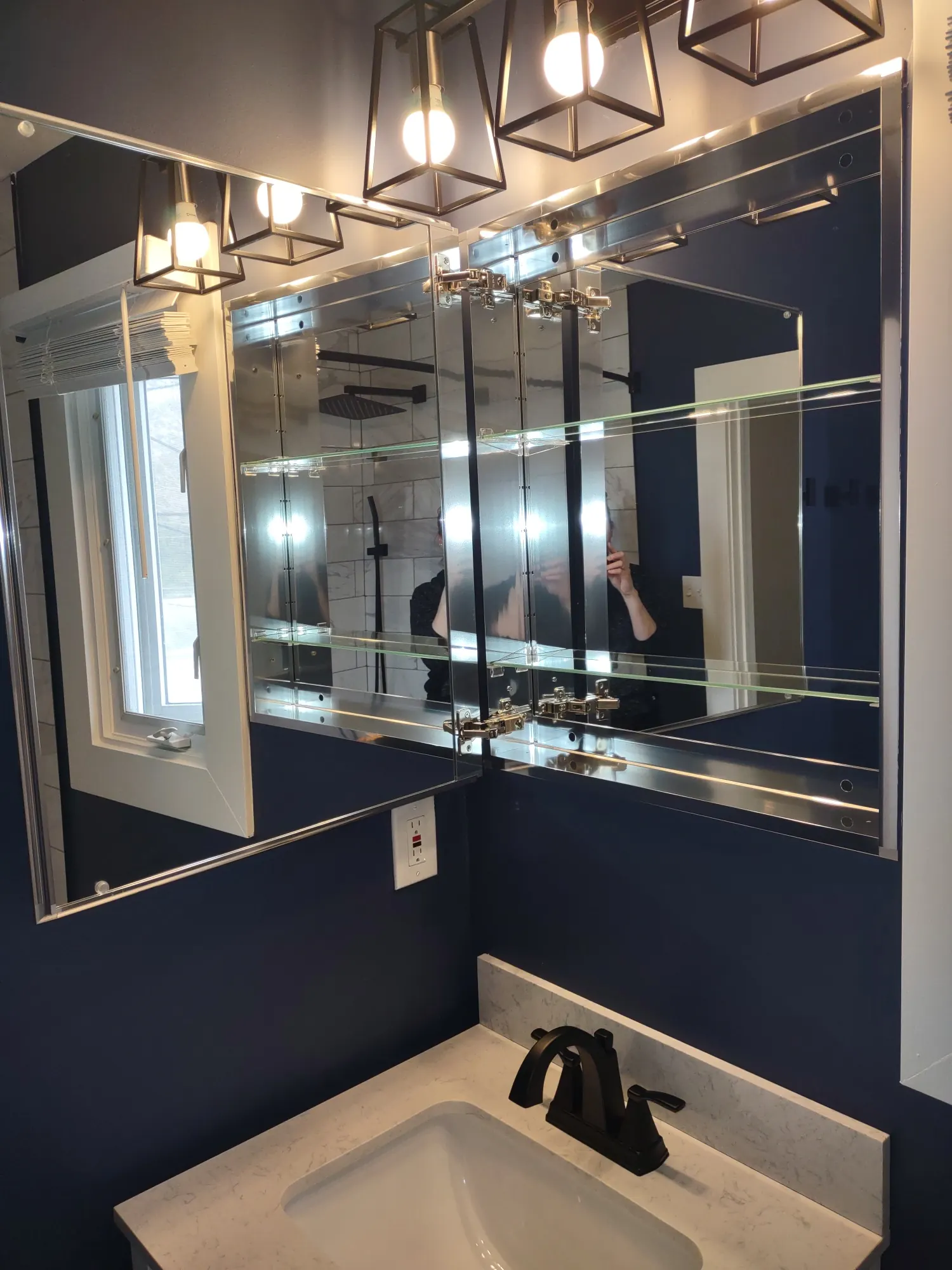Teal tiled walk-in shower beside a dark vanity