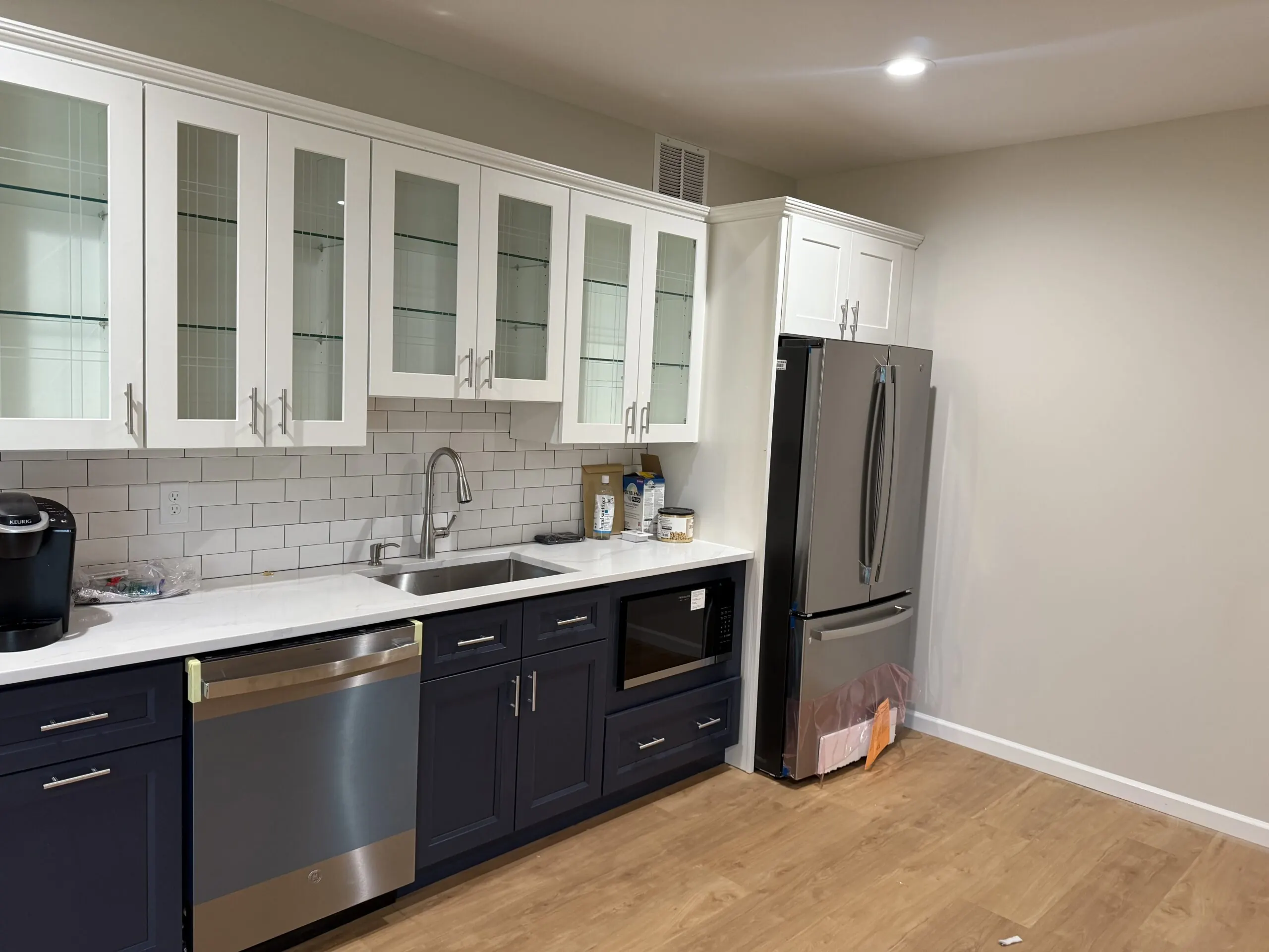White kitchen remodel with an island and gray subway tile