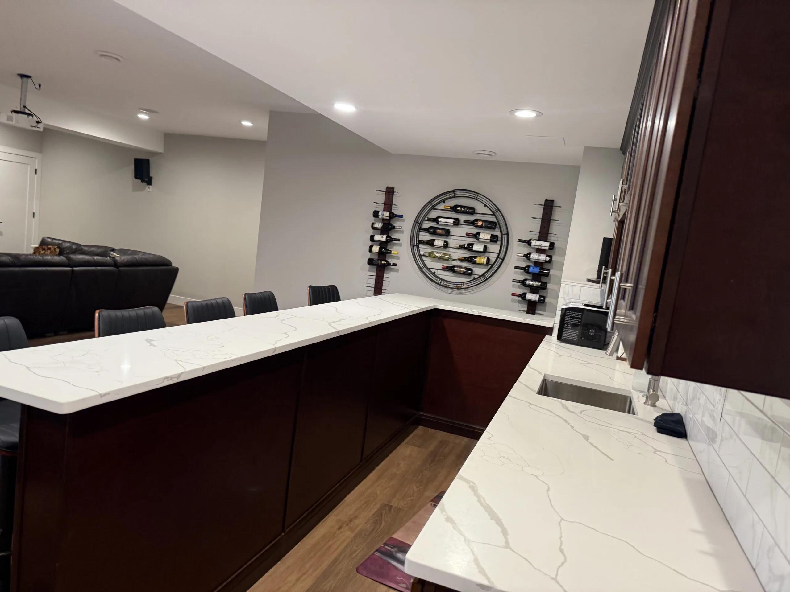 Finished basement with a sofa, vinyl wood floor, and recessed lights
