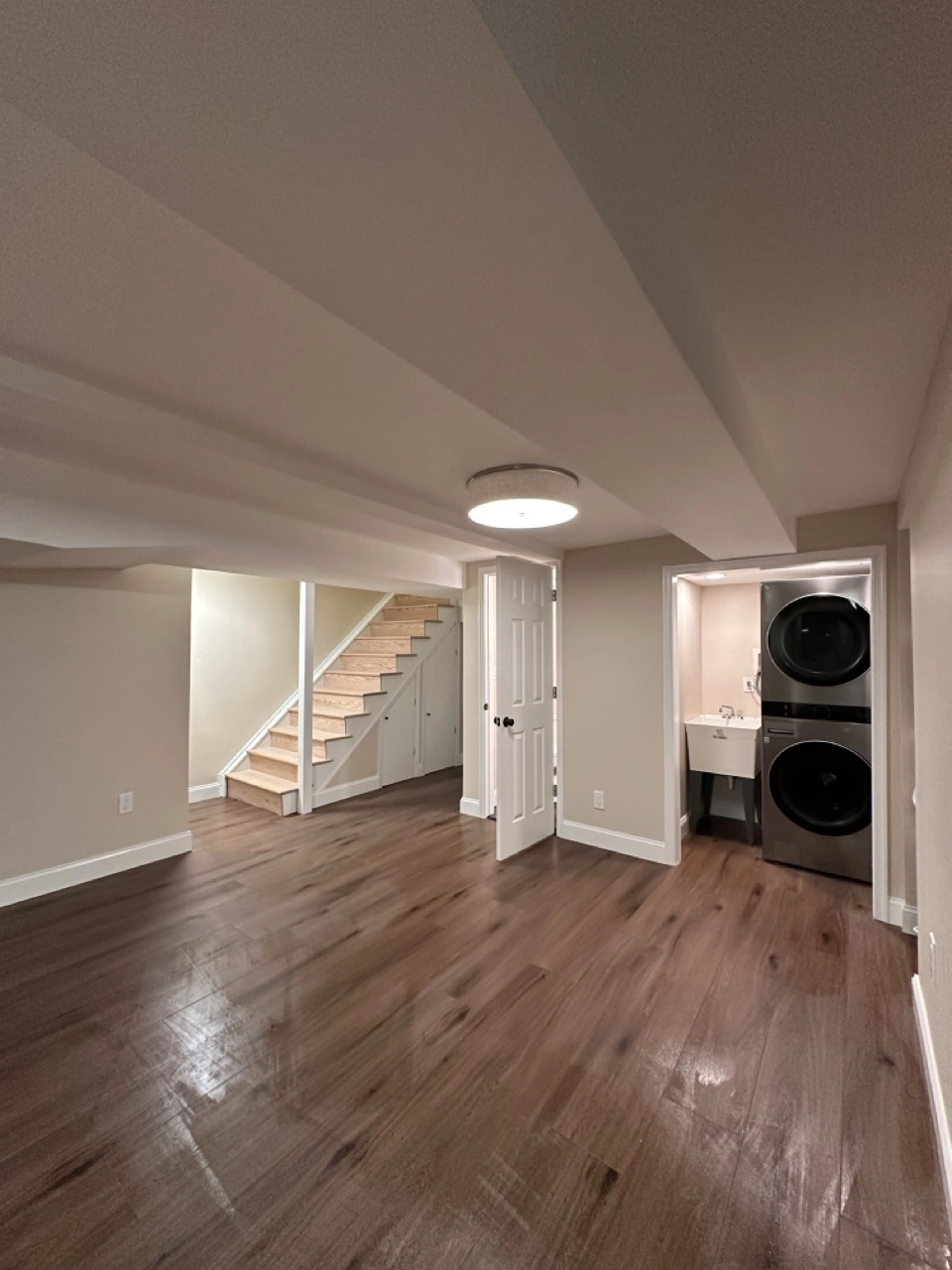 Finished basement with a sofa, vinyl wood floor, and recessed lights