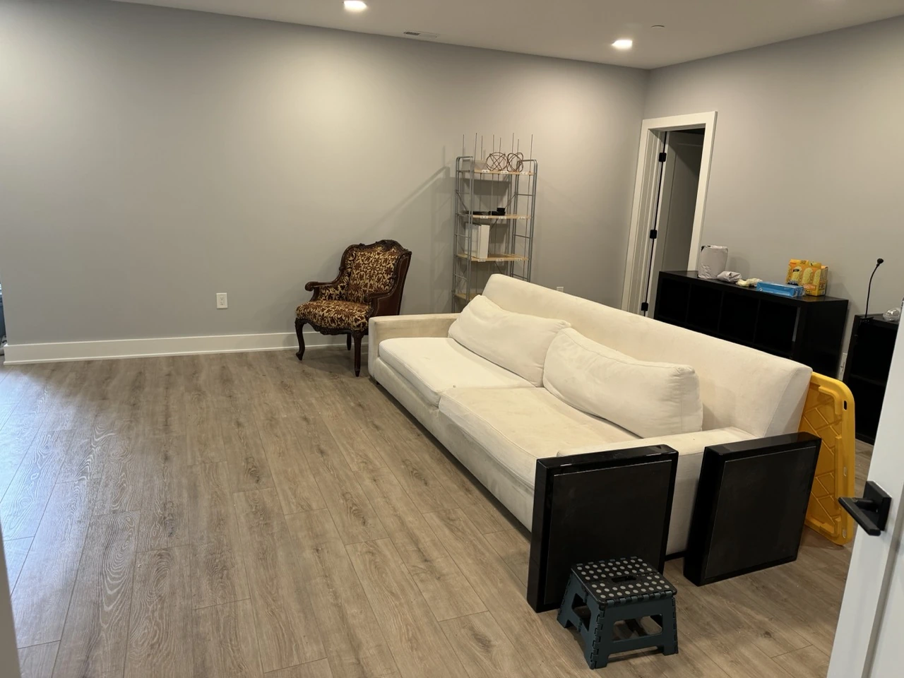 Finished basement with a sofa, vinyl wood floor, and recessed lights
