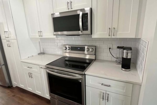 Kitchen remodel featuring white shaker cabinets, stainless steel appliances, quartz countertops, and subway tile backsplash in PA by 215Mercury