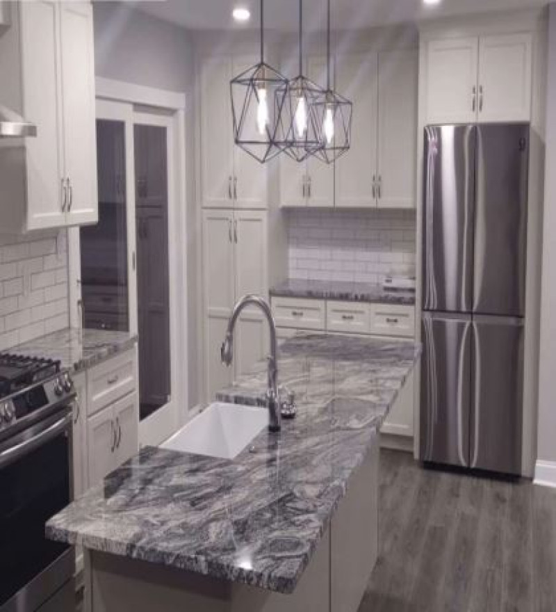 Modern kitchen remodel with marble countertops, white cabinets, stainless steel appliances, geometric pendant lights, and subway tile backsplash in PA