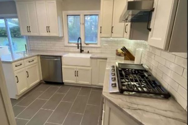 Modern kitchen renovation with white shaker cabinets, farmhouse sink, stainless steel appliances, and subway tile backsplash PA