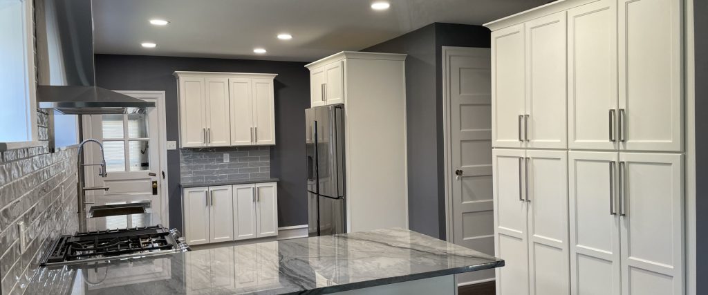 Spacious kitchen remodel with white shaker cabinets, stainless steel appliances, marble countertops, and subway tile backsplash in PA