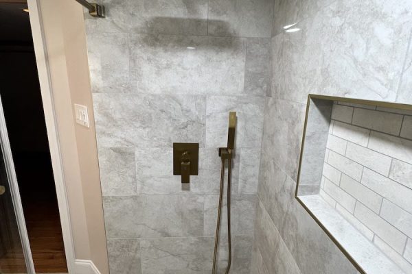 Luxury shower remodel featuring a rainfall showerhead, large gray tiles, and built-in niche in PA